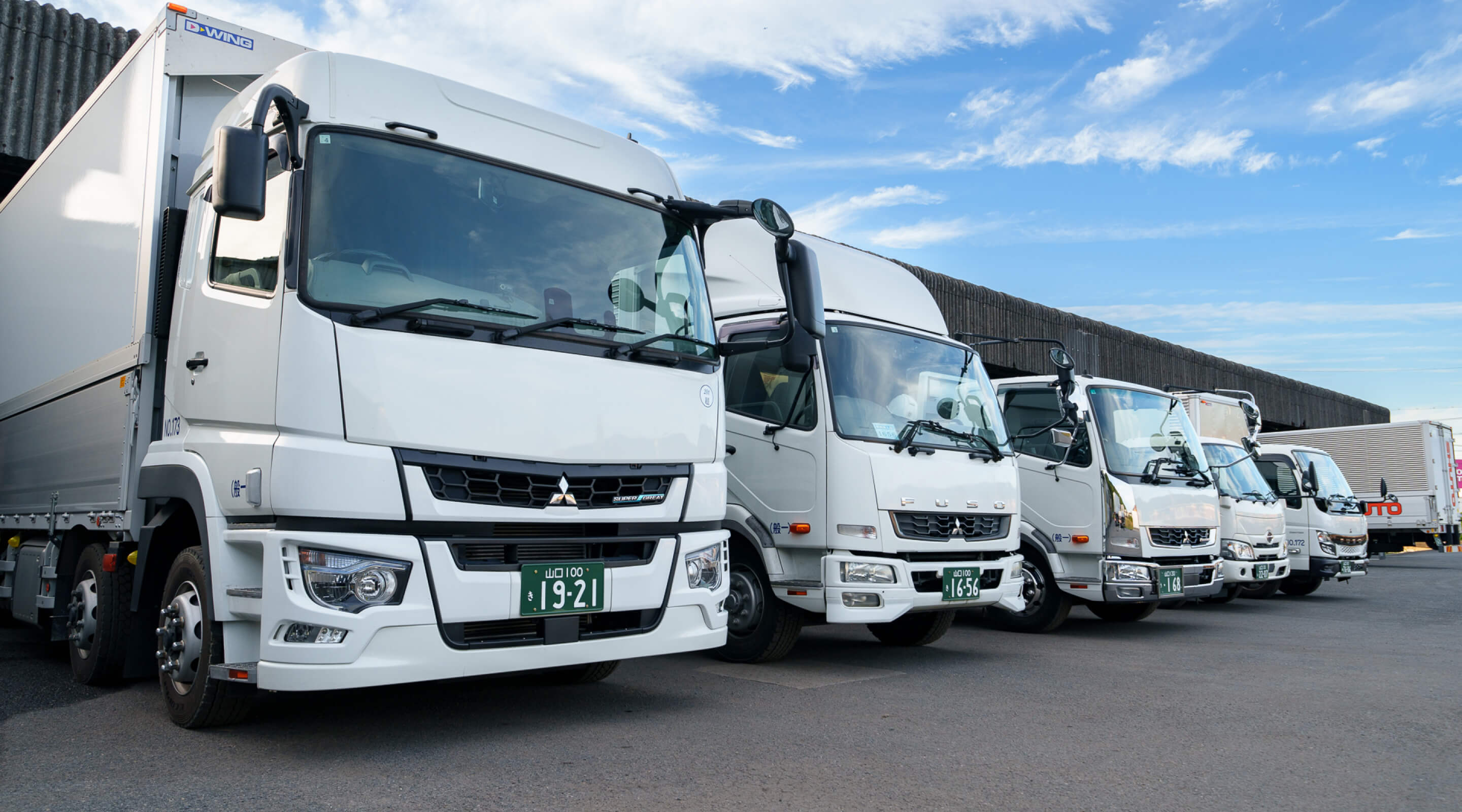 柳井海運株式会社の複数のトラックが整列している画像。全国配送の物流拠点を象徴しています。