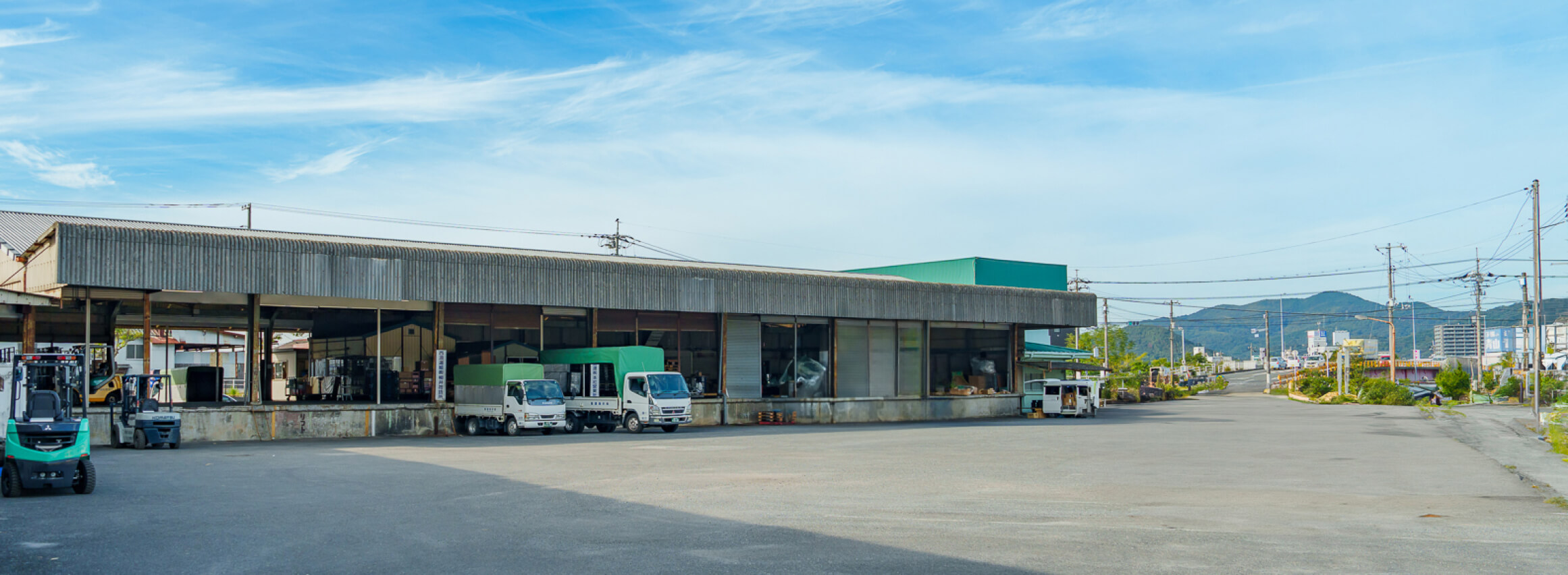 柳井海運株式会社の倉庫とトラックが並ぶ施設の外観写真