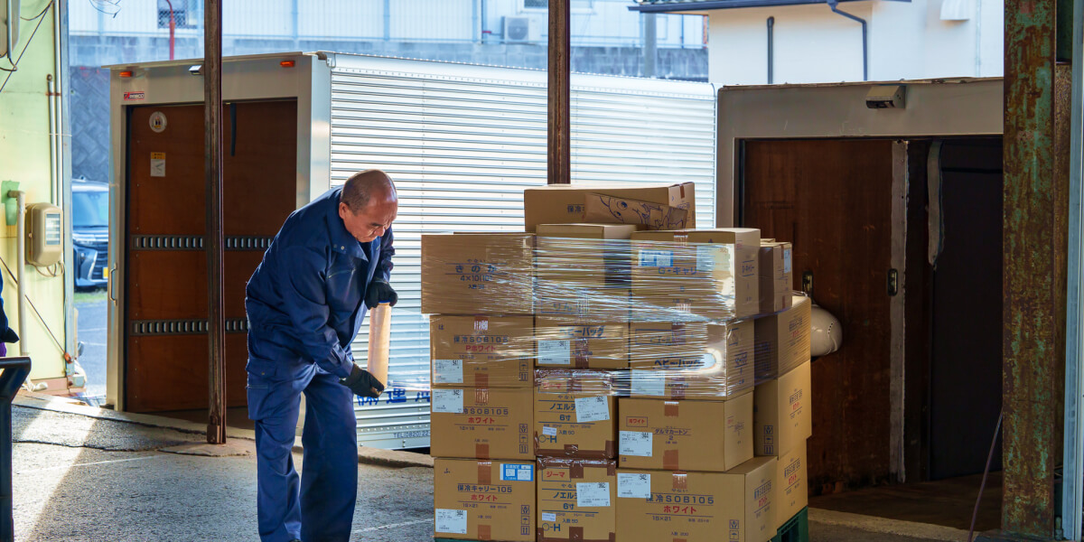 柳井海運株式会社の倉庫でスタッフが荷物を整理する様子