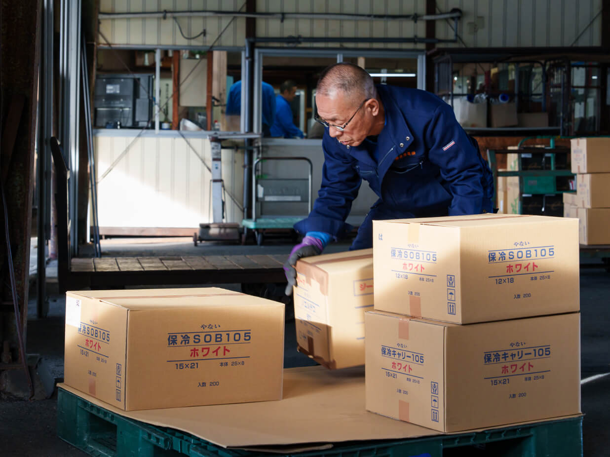 柳井海運株式会社の物流施設内での作業風景。輸送品質と実績を示す画像。